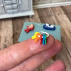 a hand holding a small ring made out of colored plastic beads