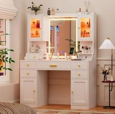 a white vanity with lighted mirror and drawers in a living room next to a window