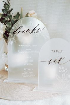 a table setting with place cards and flowers