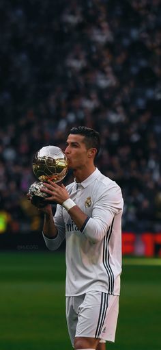 a man holding a soccer trophy in his hands