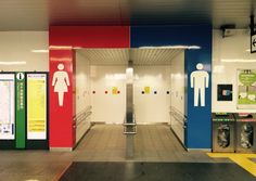 an empty public restroom with stalls and urinals on either side of the doors