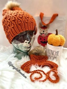 an orange knitted hat and scarf on top of a mannequin head