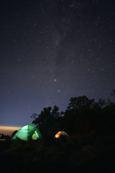 two tents set up under the stars in the night sky