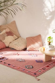 an image of a living room setting with pink and green accents on the rugs