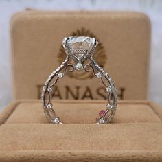 an engagement ring in a box with the name anasi engraved on it's side