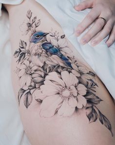 a woman's thigh with flowers and a bird on it