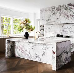 a kitchen with marble counter tops and wooden floors