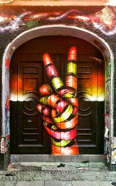 a door with graffiti on it and a hand holding the peace sign painted on it