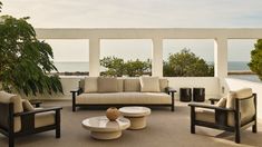 a living room filled with furniture and large windows