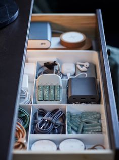 an open drawer containing various electronics and cords