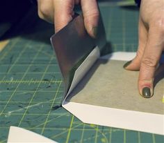 a person cutting paper with a knife on top of it