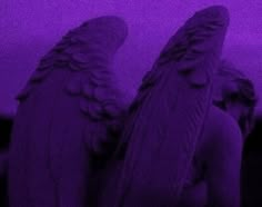 two angel statues in front of a purple sky with the light reflecting off their wings