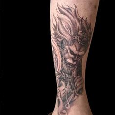 a man's leg with a dragon tattoo on it and his head in flames