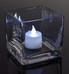 a lit candle sitting in a glass container