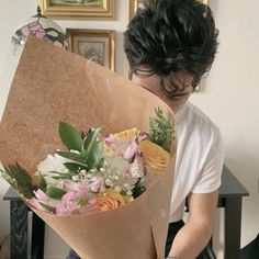 a man is holding a bouquet of flowers