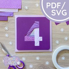 the number four is cut out of purple paper and surrounded by crafting supplies on a table