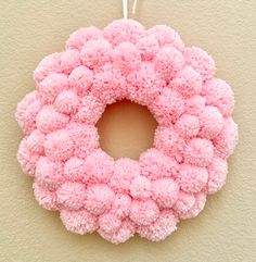 a pink wreath hanging on the wall