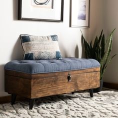 a wooden bench sitting on top of a rug next to a plant