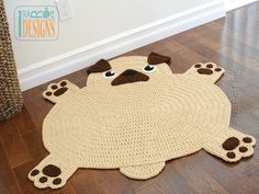 a crocheted rug with a pug dog on the floor next to it