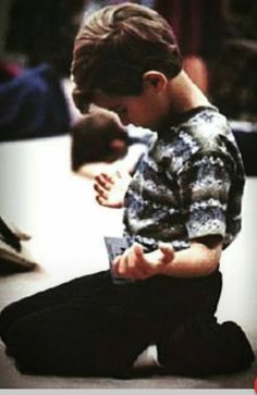 a young man sitting on the floor using his cell phone