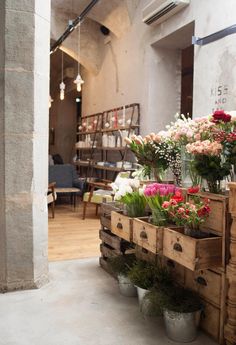 flowers are sitting in wooden crates on the floor