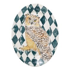 an owl is sitting on a checkered plate