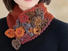 a woman wearing a crocheted scarf with flowers on it