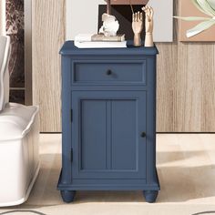 a blue cabinet sitting on top of a hard wood floor next to a white toilet