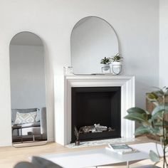 a living room filled with furniture and a fire place in front of a white fireplace