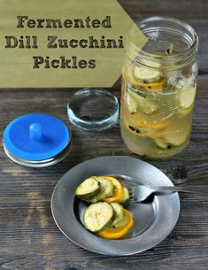 pickles are cut up and placed in a bowl next to a mason jar filled with fermented dill zucchini pickles