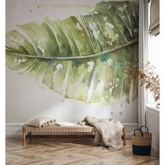 a large green leaf is on the wall next to a bench and rug in front of it