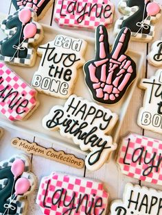 decorated cookies are displayed on a table for someone's 30th birthday party in pink, black and white