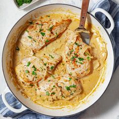 a pan filled with chicken and gravy on top of a white countertop