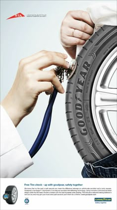 a man is holding a tire with a wrench in his hand and he is working on it