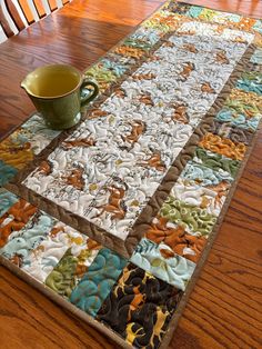 a table with a coffee cup on top of it next to a quilted placemat