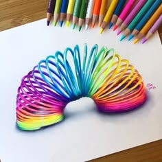 colored pencils and crayons sitting on top of a piece of paper