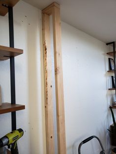 a room with some shelves and tools on the wall next to it, including a sawhorse