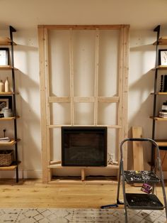 a living room filled with furniture and a flat screen tv on top of a wooden shelf