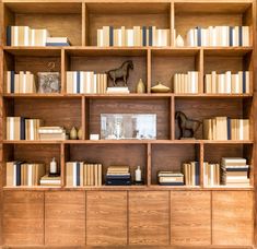 a bookshelf filled with lots of books and figurines on top of it