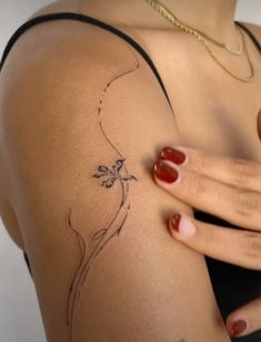 a woman's arm with a flower tattoo on the back of her left shoulder