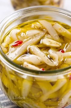 two jars filled with pickled vegetables on top of a checkered table cloth next to each other