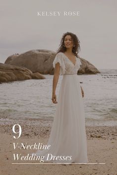 a woman standing on top of a beach next to the ocean wearing a wedding dress