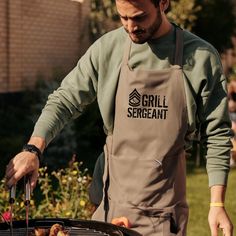 a man in an apron grilling food on a grill