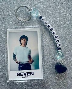 a keychain with an image of a person on it and the words seven hanging from it