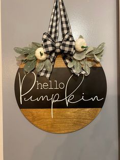 a sign that says hello pumpkin in front of a door with leaves and flowers on it