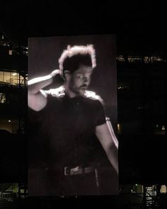 a black and white photo of a man wearing a hat in front of a building