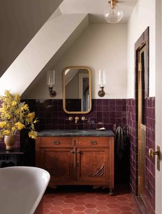 the bathroom is decorated in purple and gold with an interesting mirror on the wall above the sink