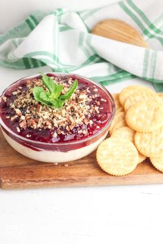 a bowl of fruit and crackers on a cutting board