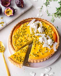 a cheesecake on a plate with a slice cut out and topped with white flowers