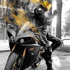 a man sitting on top of a motorcycle wearing a yellow helmet and black leather pants